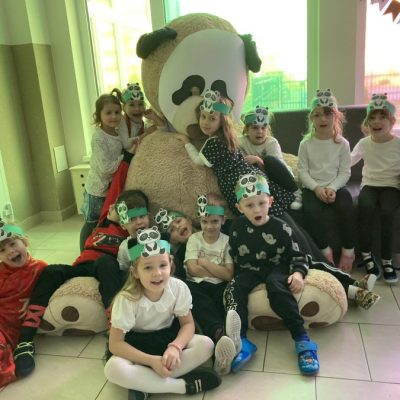 Dzieci z dużą maskotką pandy