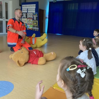 Dzieci uczą się pierwszej pomocy od ratownika medycznego