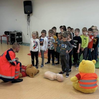 Dzieci wykonują praktyczne ćwiczenia z zakresu pierwszej pomocy medycznej